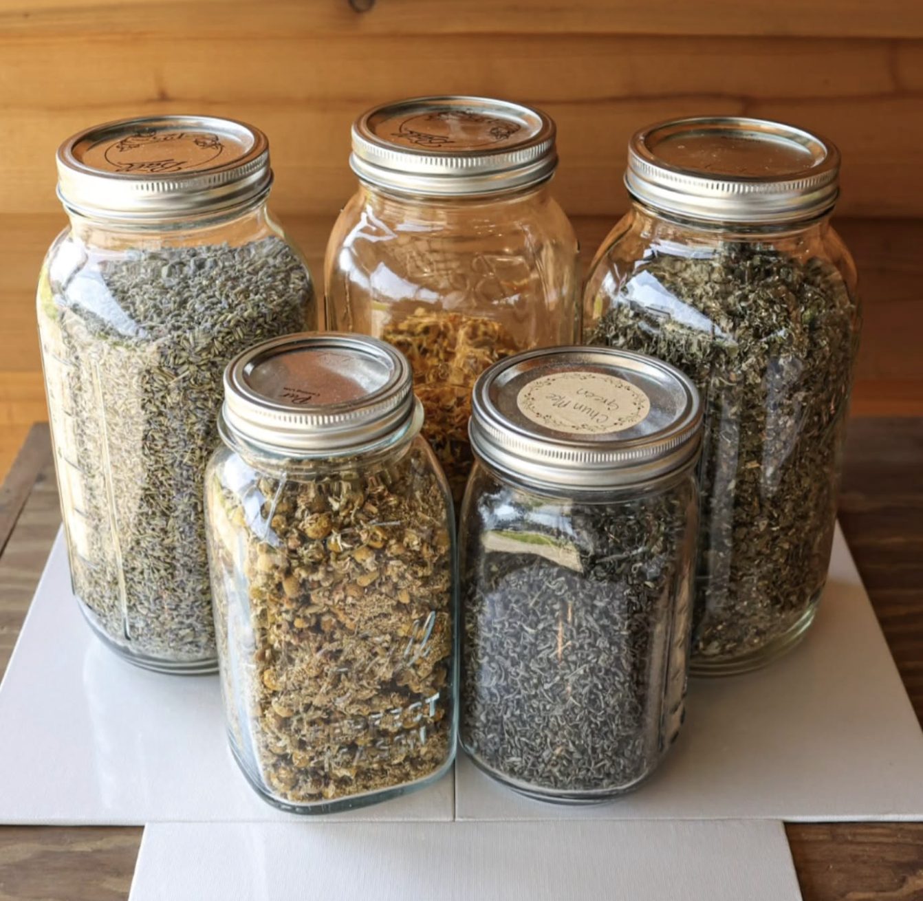 Large glass jars of loose herbs &mdash; chamomile, lavender and others &mdash; waiting to be blended